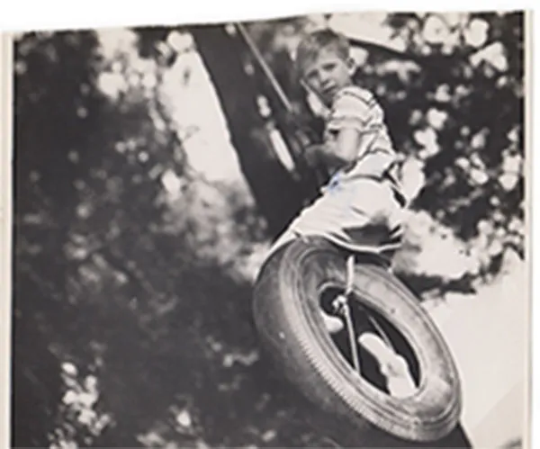Young boy sitting on a tire swing at the children’s home